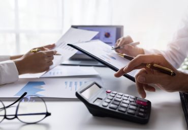 Team of Business people working at workplace with tablet and document, doing planning analyzing Tax financial report, business plan investment, finance analysis Economic business discussions. stock photo
