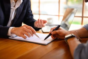 two professionals discussing paperwork at hand