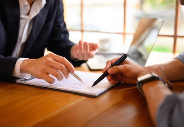 two professionals discussing paperwork at hand