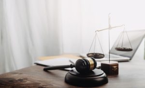 Business and lawyers discussing contract papers with brass scale on desk in office. Law, legal services, advice, justice and law concept picture with film grain effect