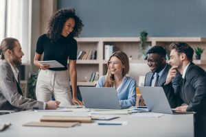 business meeting taking place among 5 people in office