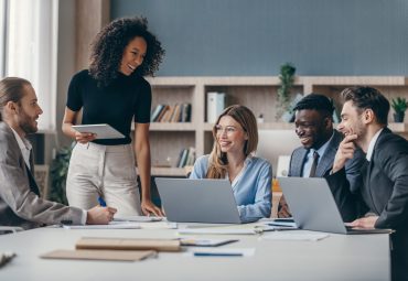 business meeting taking place among 5 people in office