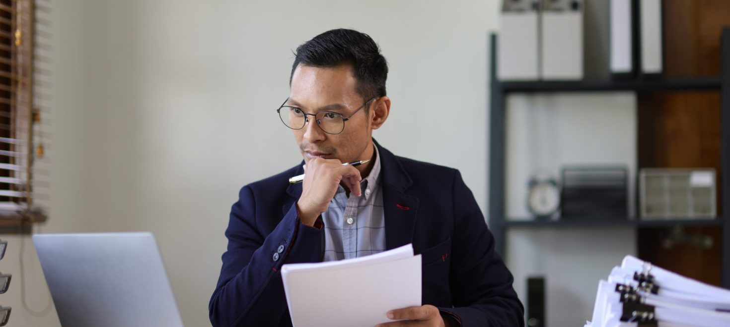 Man looking at computer with a hand on his chin