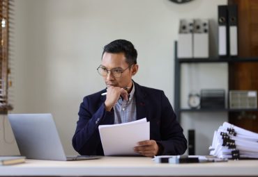 Man looking at computer with a hand on his chin