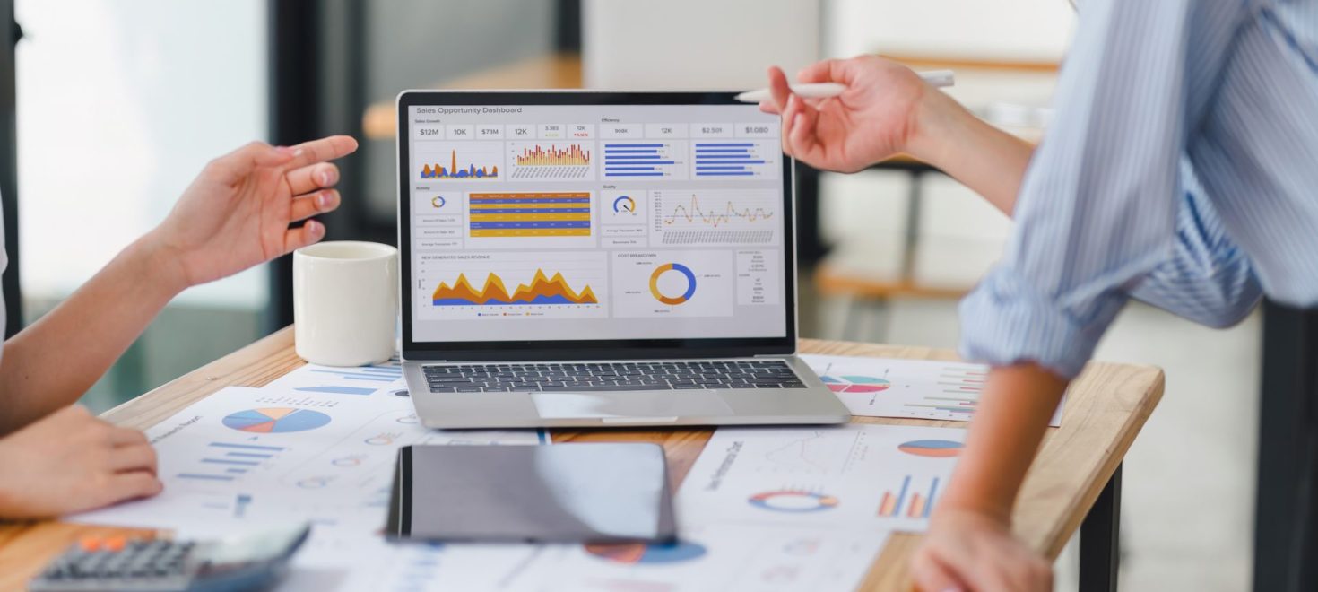 Two workers pointing at a analytics dashboard