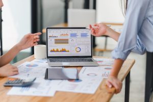 Two workers pointing at a analytics dashboard