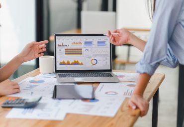 Two workers pointing at a analytics dashboard