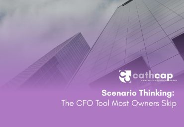 CFO reviewing a three-scenario planning framework with a business owner at a whiteboard