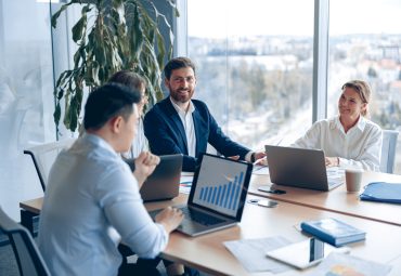 Creative business team working on project in modern office with panoramic view. Concept of teamwork